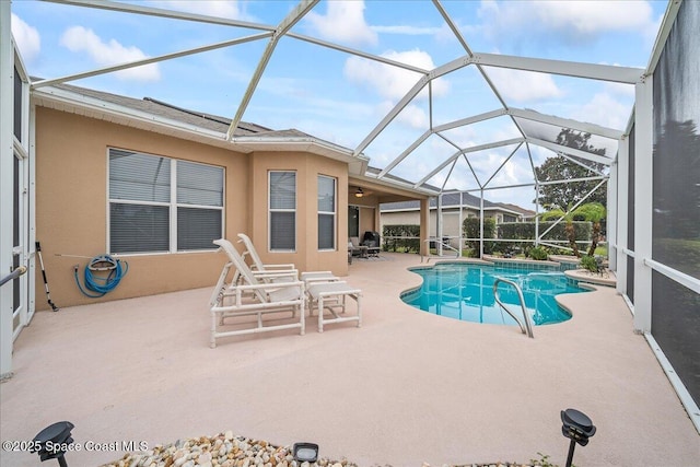 view of pool with a patio and glass enclosure