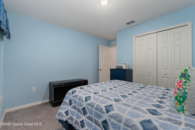 carpeted bedroom featuring a textured ceiling and a closet