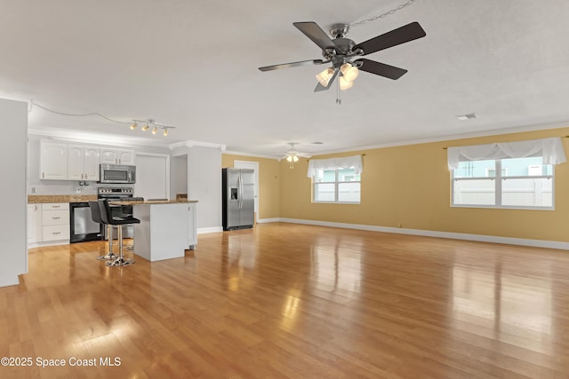 unfurnished living room featuring light hardwood / wood-style floors, plenty of natural light, crown molding, and ceiling fan