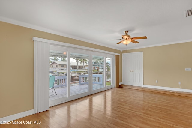 unfurnished room with light wood-type flooring, ceiling fan, and ornamental molding