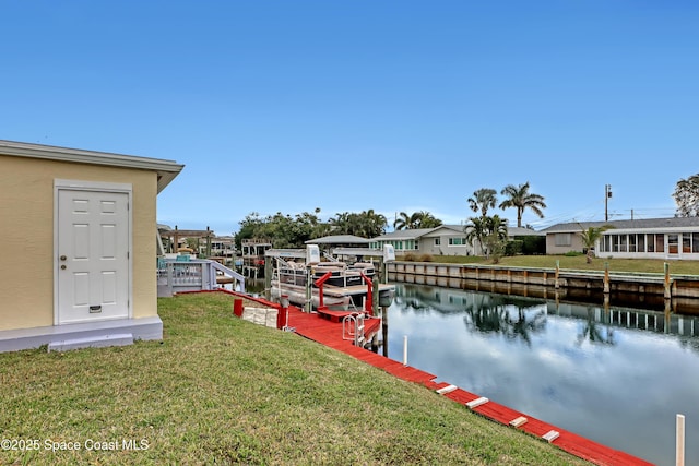 view of dock featuring a lawn and a water view