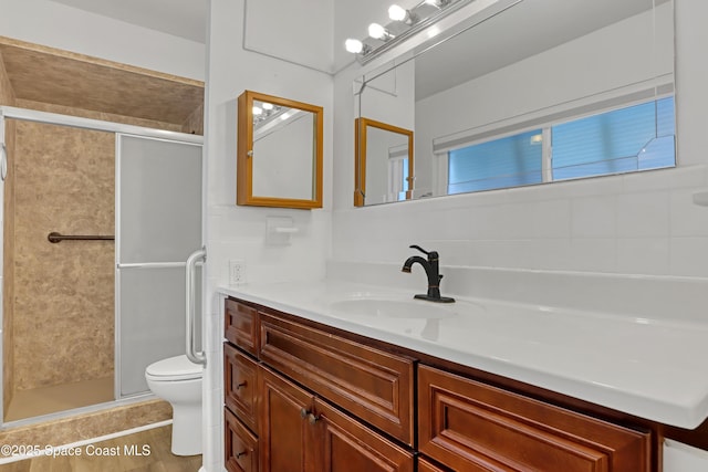 bathroom with toilet, a shower with shower door, and vanity