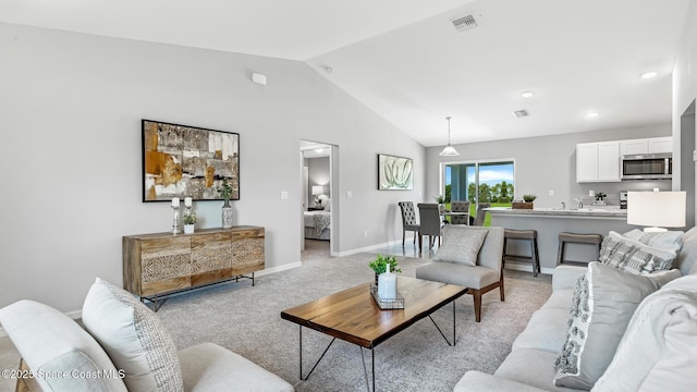 carpeted living room featuring vaulted ceiling