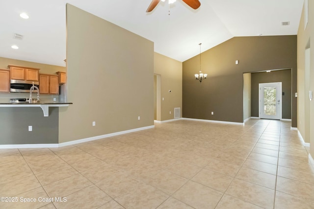 unfurnished living room with light tile patterned flooring, ceiling fan with notable chandelier, and high vaulted ceiling