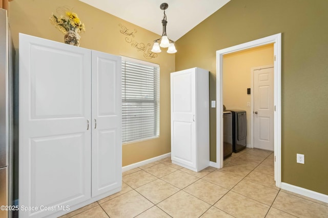 corridor featuring vaulted ceiling, separate washer and dryer, light tile patterned floors, and an inviting chandelier