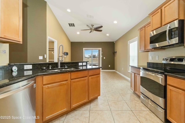 kitchen with ceiling fan, lofted ceiling, dark stone countertops, sink, and appliances with stainless steel finishes