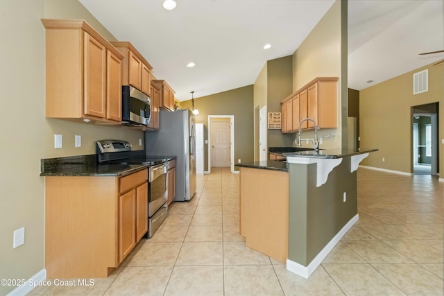 kitchen with light tile patterned floors, kitchen peninsula, appliances with stainless steel finishes, lofted ceiling, and dark stone counters