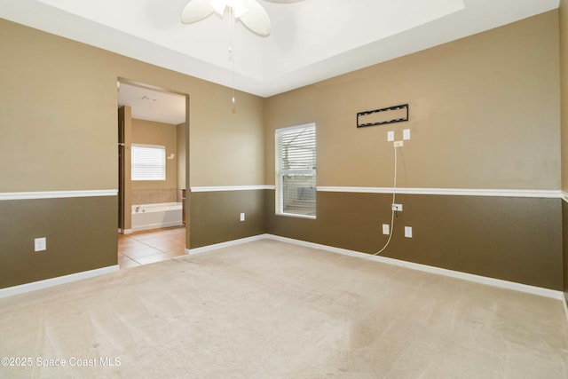 carpeted spare room with ceiling fan and a wealth of natural light