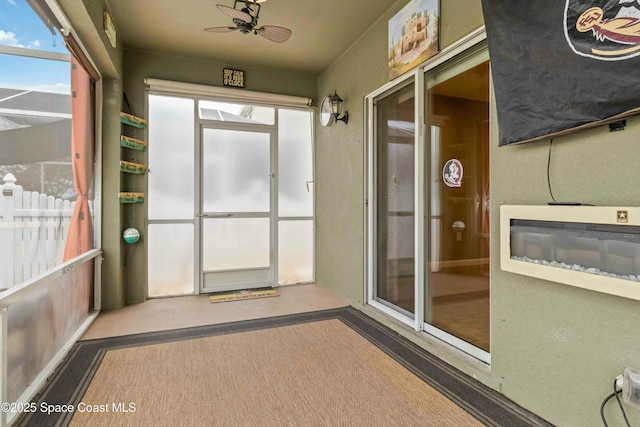 unfurnished sunroom with ceiling fan