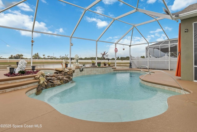 view of pool with a patio area and glass enclosure