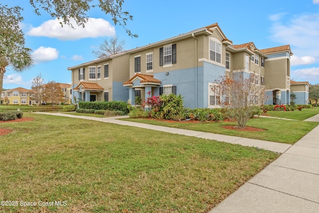 mediterranean / spanish home featuring a front lawn