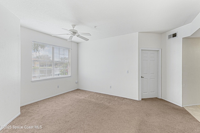 empty room featuring ceiling fan and light carpet