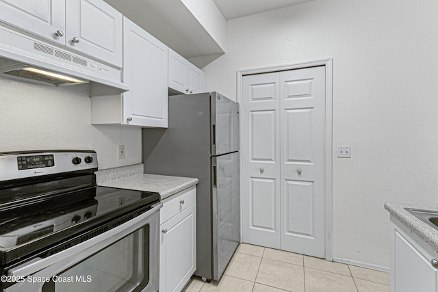 kitchen with white cabinets, appliances with stainless steel finishes, and light tile patterned floors