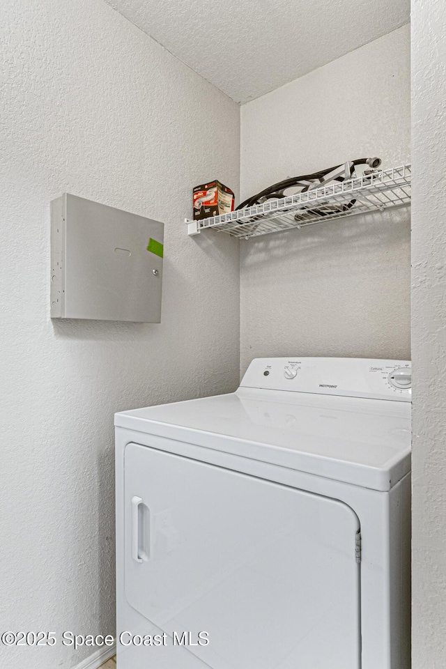 laundry room featuring washer / dryer and a textured ceiling