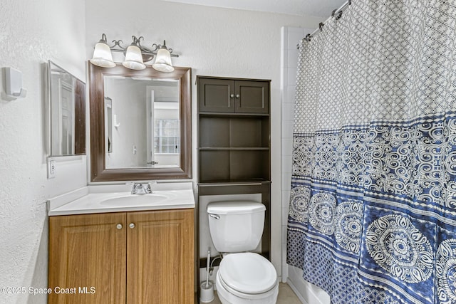 bathroom featuring toilet, vanity, and a shower with curtain