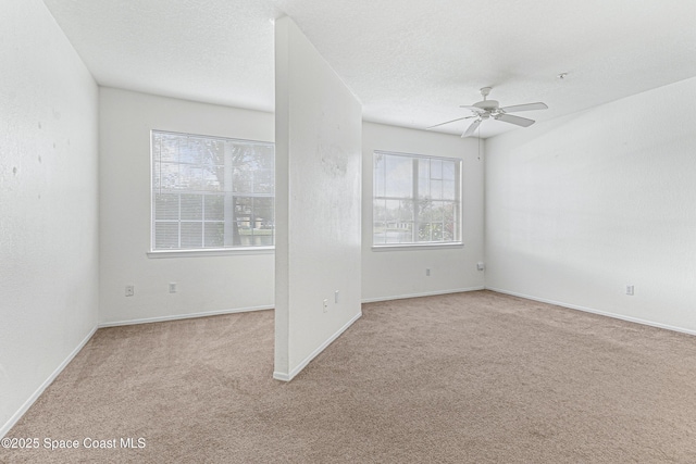 carpeted spare room with a textured ceiling and ceiling fan