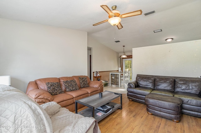 living room with ceiling fan, lofted ceiling, and light hardwood / wood-style floors