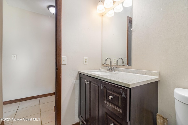 bathroom with toilet, tile patterned flooring, and vanity