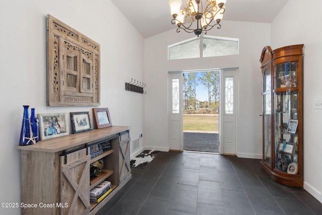 tiled foyer with vaulted ceiling and a notable chandelier