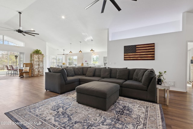 living room with ceiling fan, dark hardwood / wood-style floors, and high vaulted ceiling