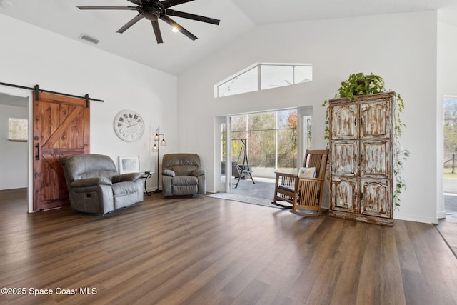 unfurnished room with ceiling fan, a barn door, high vaulted ceiling, and dark hardwood / wood-style flooring