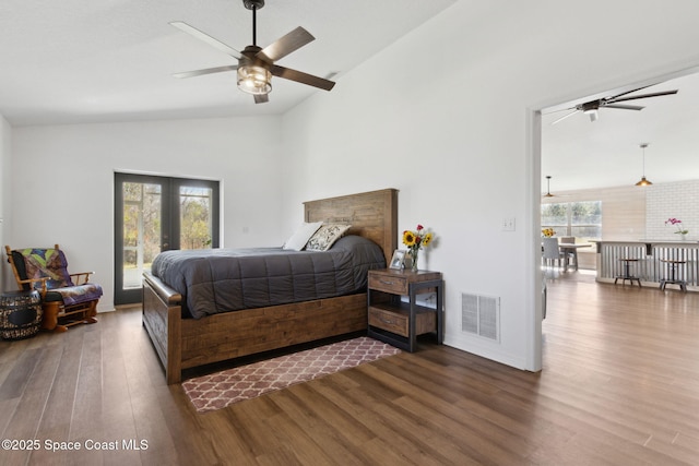 bedroom featuring access to exterior, dark wood-type flooring, french doors, and vaulted ceiling