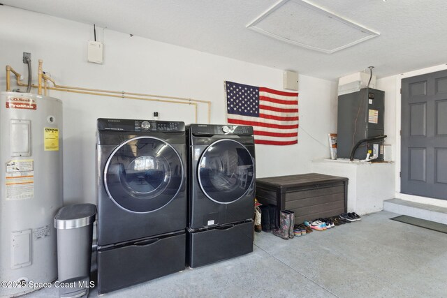 laundry area with heating unit, washing machine and dryer, and water heater