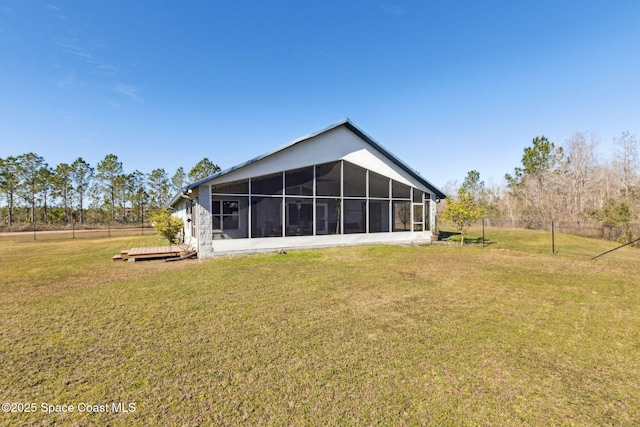 rear view of property with a sunroom, a deck, and a lawn