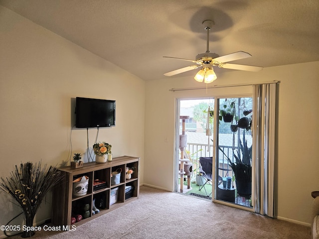 interior space with ceiling fan, carpet flooring, and vaulted ceiling