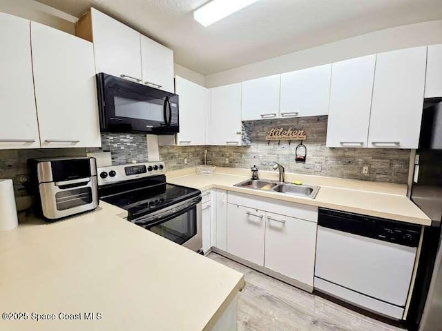 kitchen with white cabinetry, sink, and black appliances