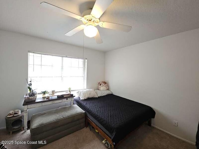 bedroom featuring ceiling fan and dark carpet