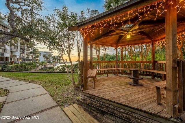 deck at dusk with a gazebo and a lawn