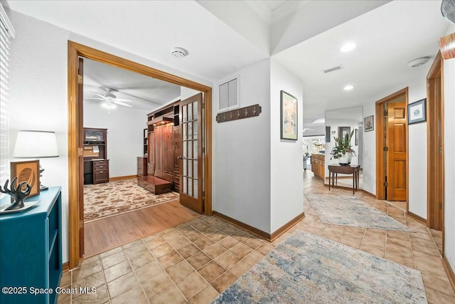 hallway with light tile patterned floors and a barn door