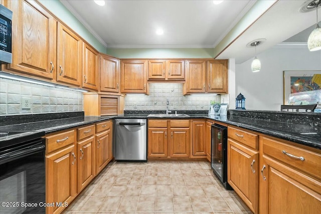 kitchen featuring appliances with stainless steel finishes, dark stone countertops, sink, hanging light fixtures, and ornamental molding