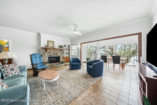 tiled living room featuring ceiling fan, a stone fireplace, ornamental molding, and a textured ceiling