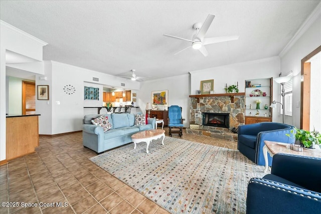 tiled living room featuring ceiling fan, crown molding, a stone fireplace, and a textured ceiling