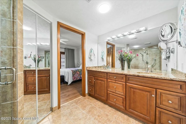 bathroom featuring tile patterned floors, a shower with shower door, and vanity