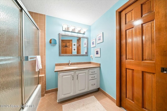 bathroom with bath / shower combo with glass door, a textured ceiling, vanity, and tile patterned flooring