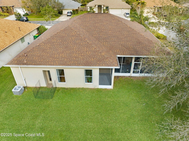 rear view of property featuring a yard and a sunroom