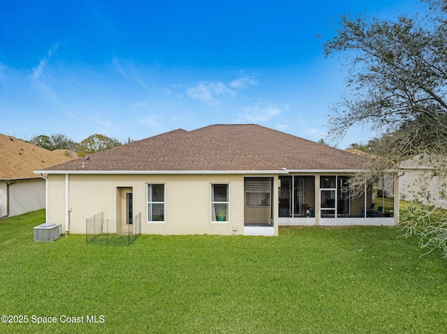 rear view of property featuring a lawn, a sunroom, and central air condition unit