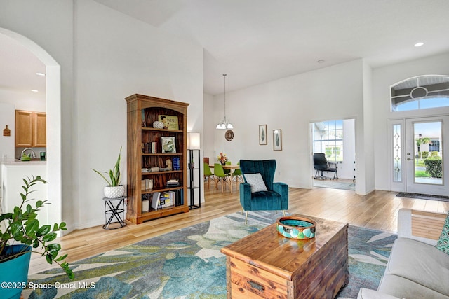 living room featuring a towering ceiling and light wood-type flooring