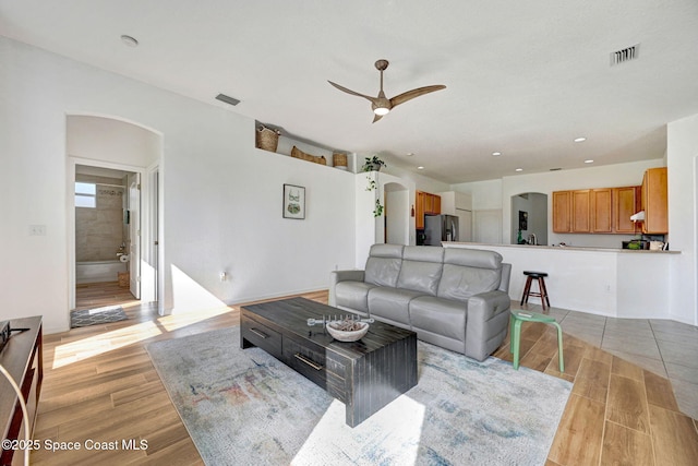 living room featuring ceiling fan and light hardwood / wood-style flooring