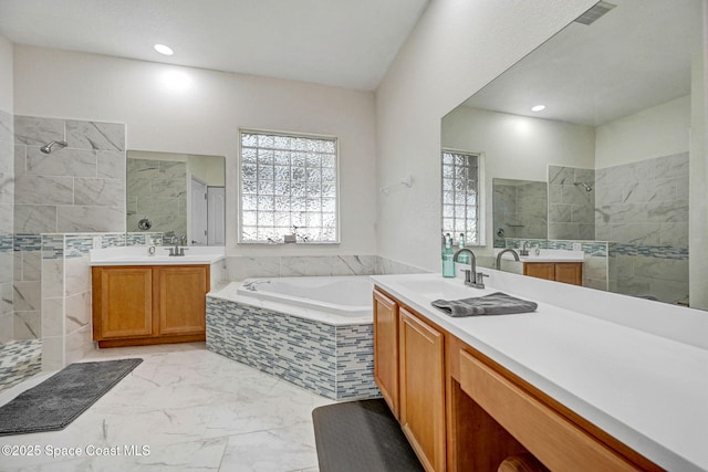 bathroom featuring vanity and tiled bath