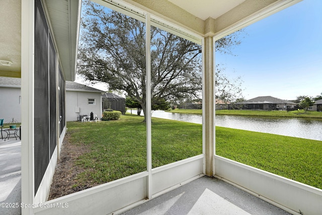 unfurnished sunroom featuring a water view