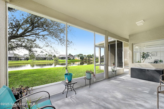 unfurnished sunroom featuring a water view