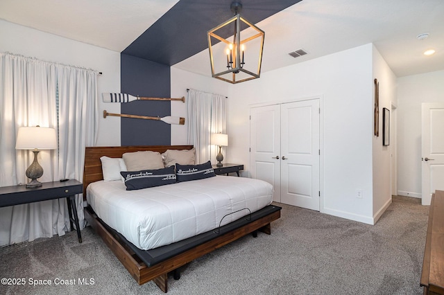 carpeted bedroom with a closet and a chandelier