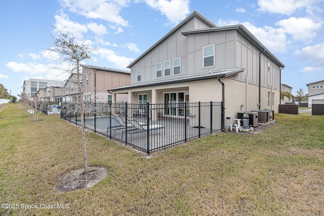 back of property featuring central air condition unit, a patio area, and a yard