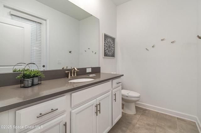 bathroom with toilet, vanity, and tile patterned flooring