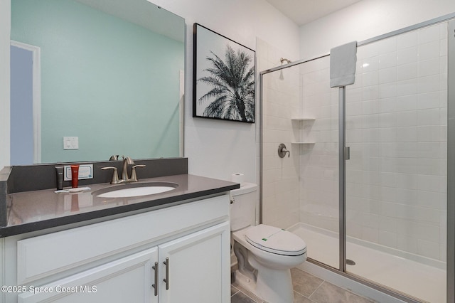 bathroom featuring toilet, tile patterned flooring, an enclosed shower, and vanity