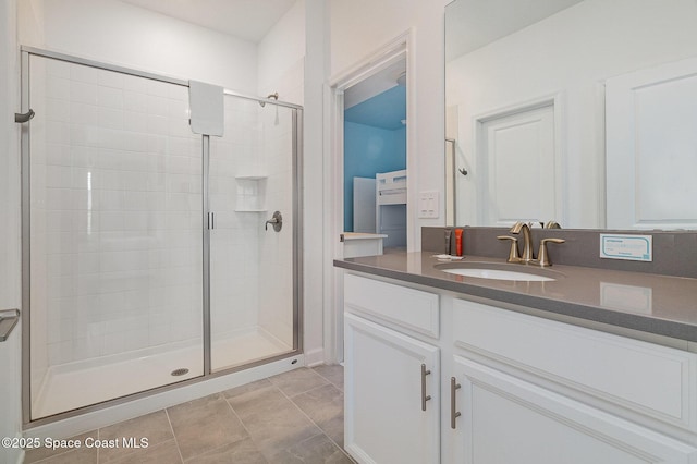 bathroom featuring tile patterned flooring, walk in shower, and vanity